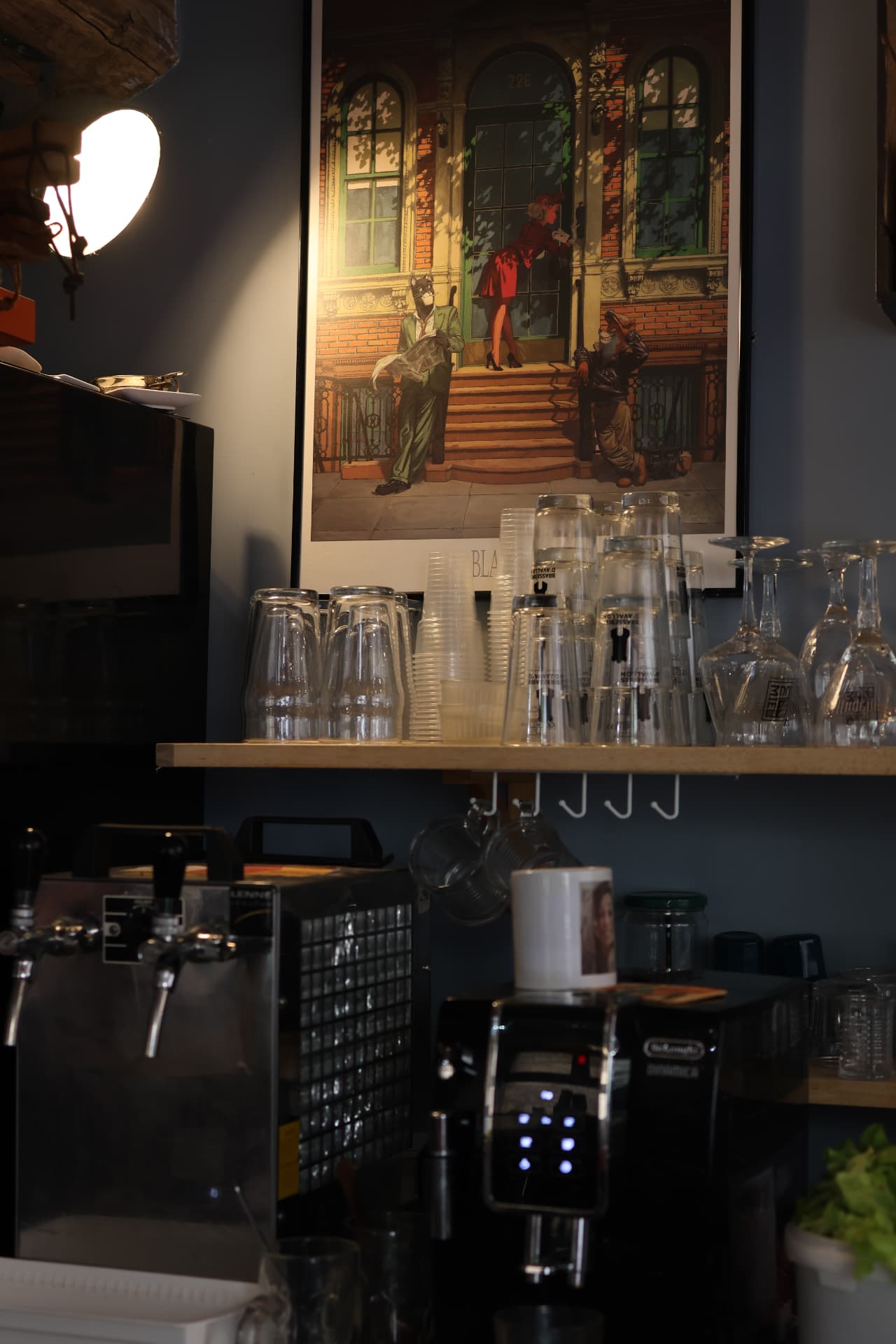 Détail du bar : verres, machine à café et affiche vintage